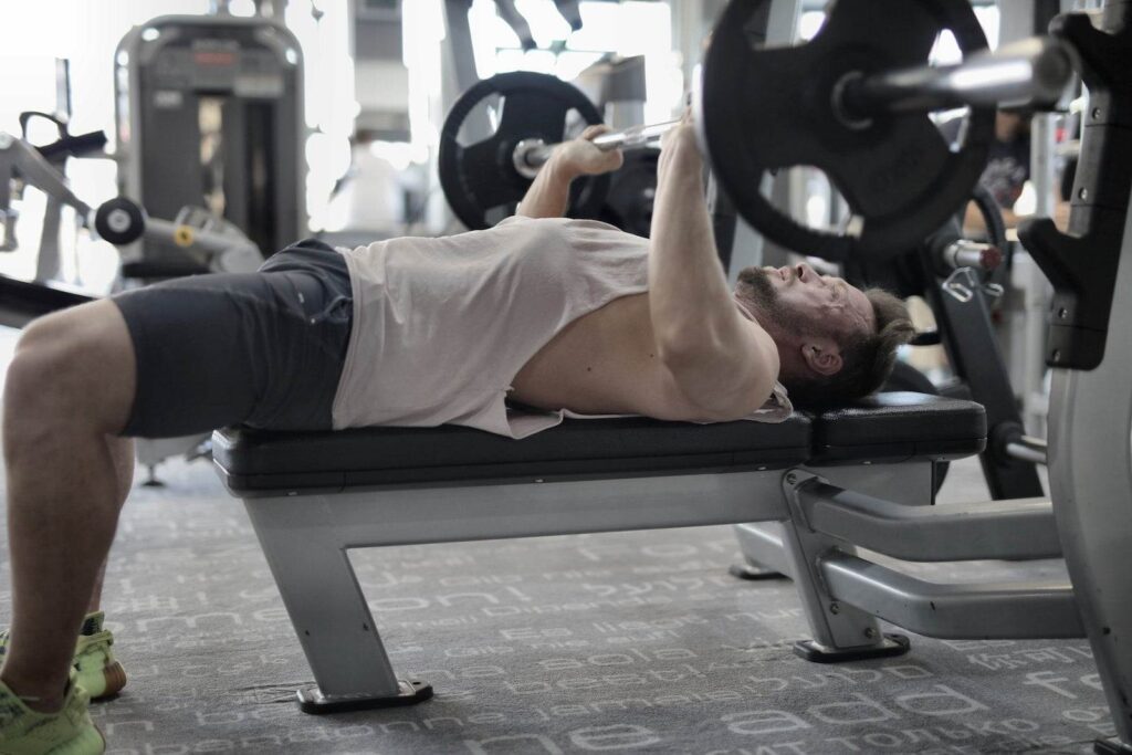 Strong sportsman chest press in modern gym