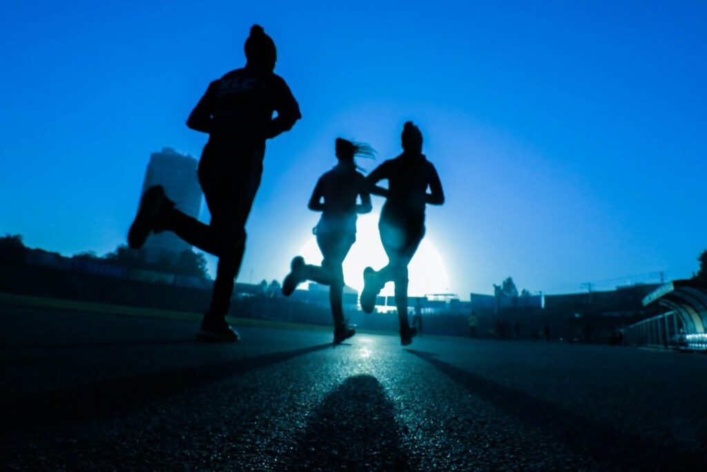 silhouette of three women running: one of cardio exercises.