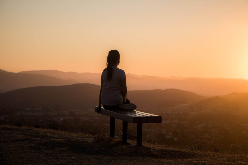 meditation woman sitting on bench over viewing mountain